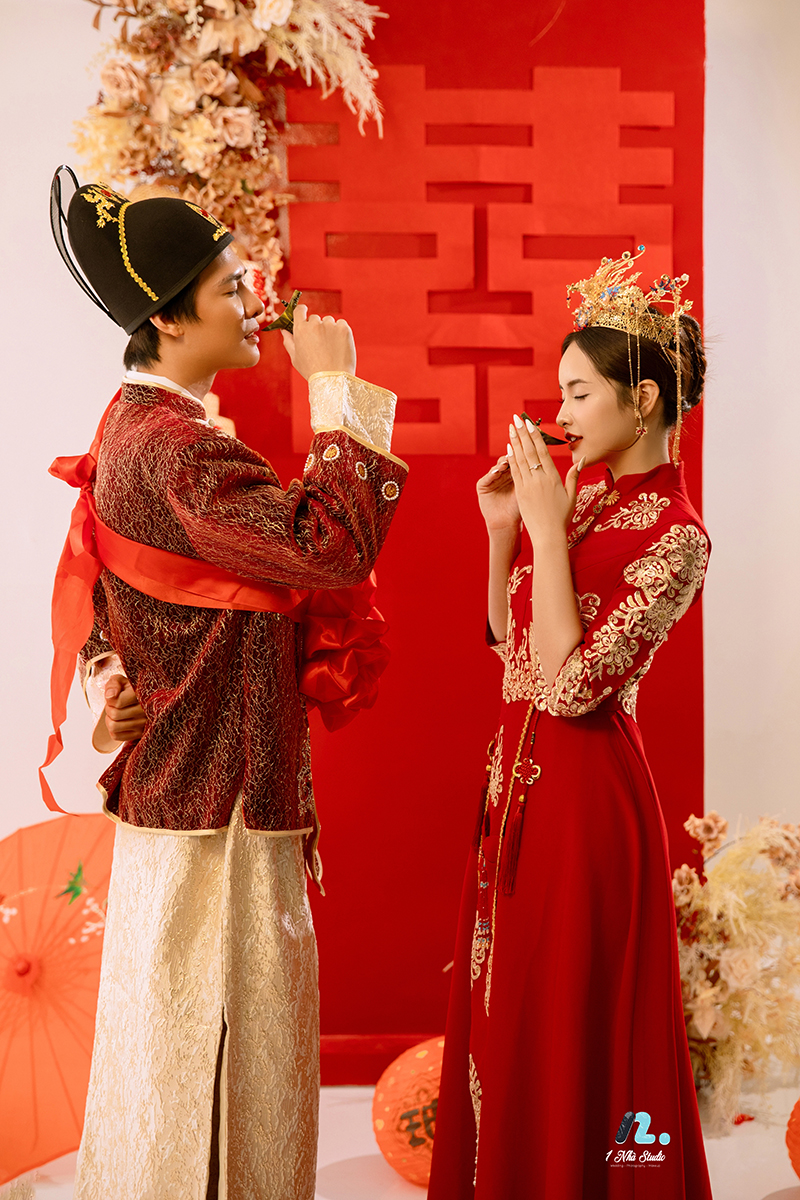 Ảnh cưới phong cách Trung Hoa cổ trang với áo khỏa đỏ, mũ phượng và phông chữ Hỷ