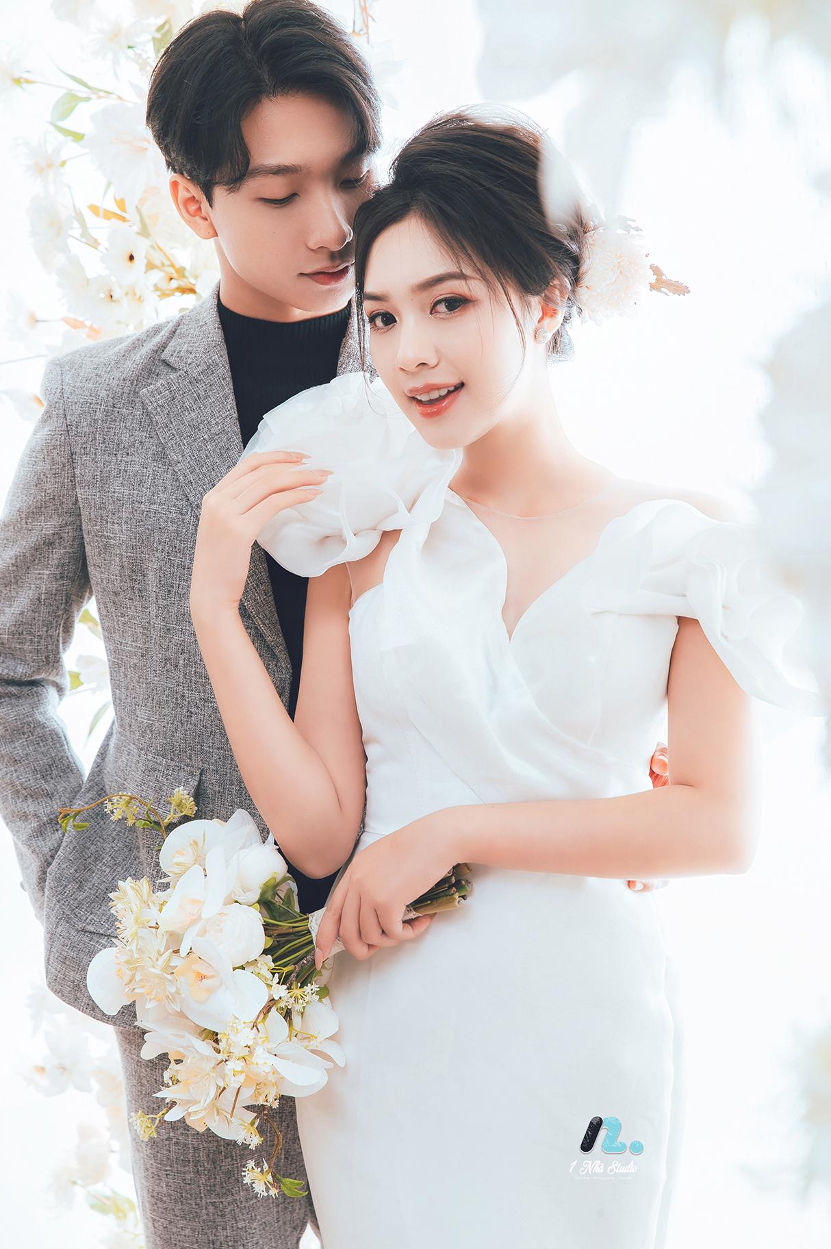Chú rể mặc vest đen tạo dáng trong studio