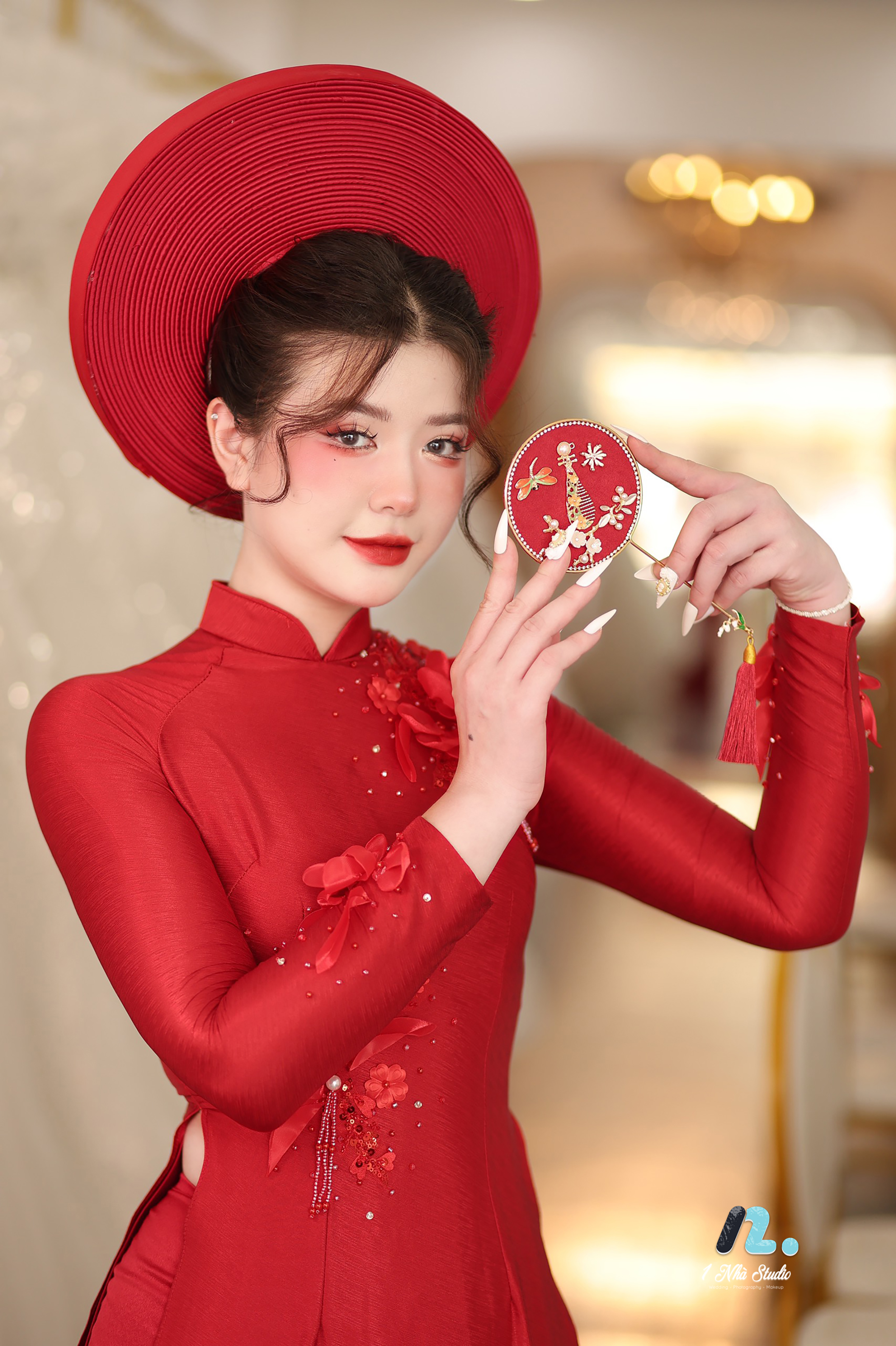 Cô dâu duyên dáng trong tà áo dài cưới đỏ truyền thống đính hoa nổi và mấn đội đầu trong ngày cưới